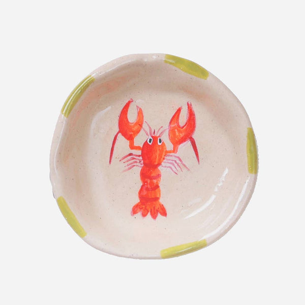 Round ceramic dish with a red lobster design on a white background