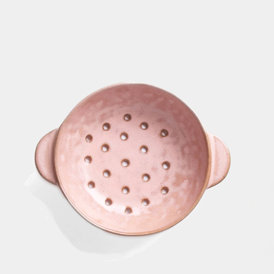 Pink colander on a light gray background