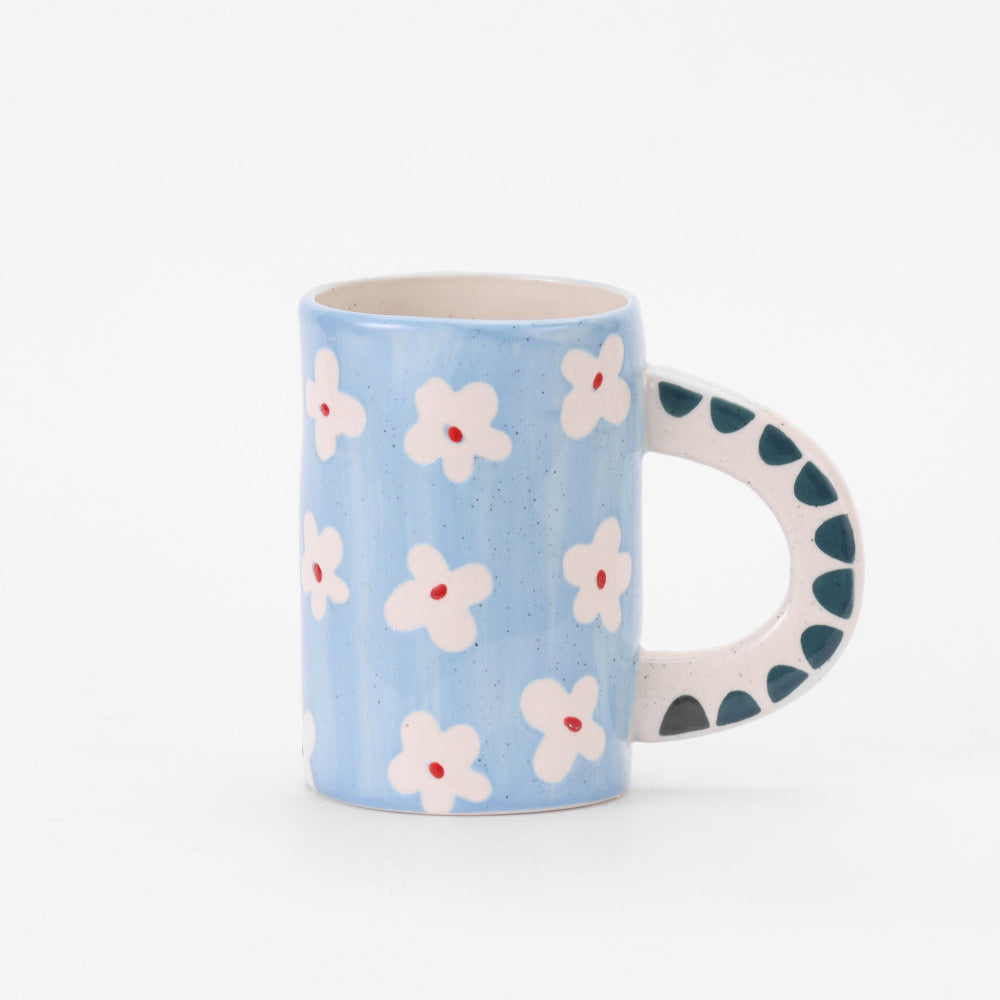 Blue mug with white floral pattern on a white background