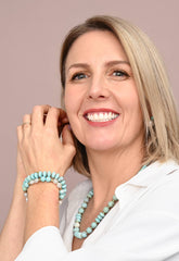 Woman wearing turquoise jewelry against a beige background