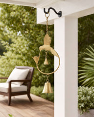 Decorative wind chime hanging from a porch with greenery in the background