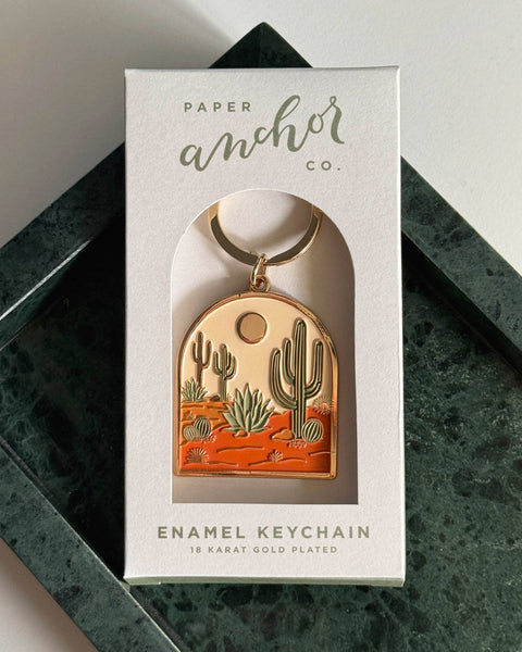 Enamel keychain in a 'Paper Anchor Co.' box on a dark surface