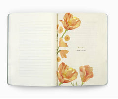 An open lined journal or notebook with cream pages, decorated on the right side with watercolor-style orange and yellow flowers and small printed text, shown on a white background.