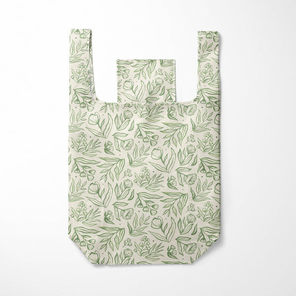Reusable shopping bag with green leaf pattern on a white background
