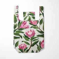 Reusable shopping bag with pink floral and green leaf pattern on a white background