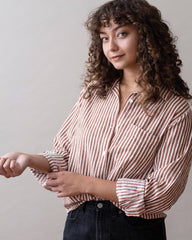 Woman wearing a striped shirt against a plain background