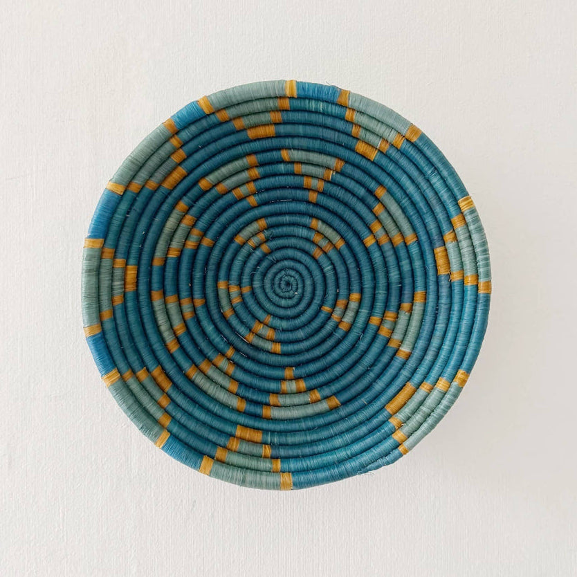 Woven basket with blue and yellow pattern on a white background