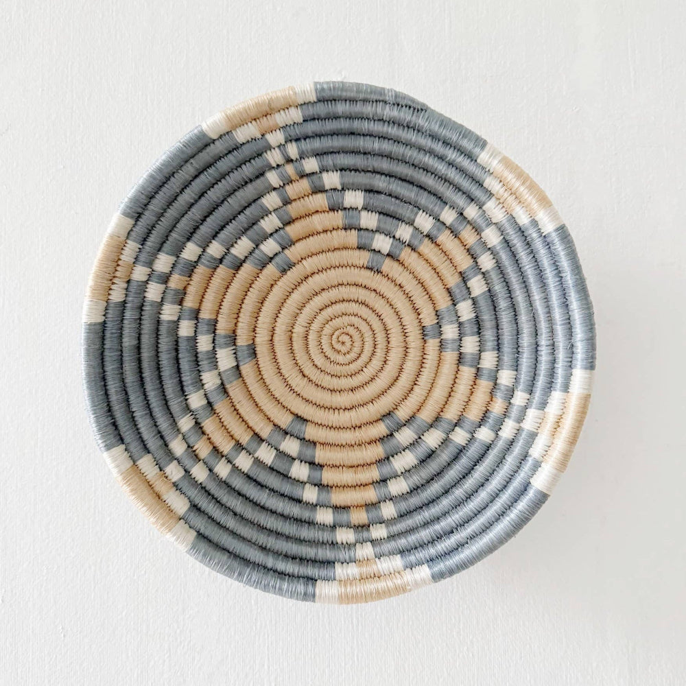 Woven basket with concentric circle pattern on a white background