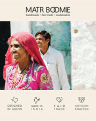 Woman wearing a pink shawl with a man in the background, featuring Matr Boomie branding and product attributes.