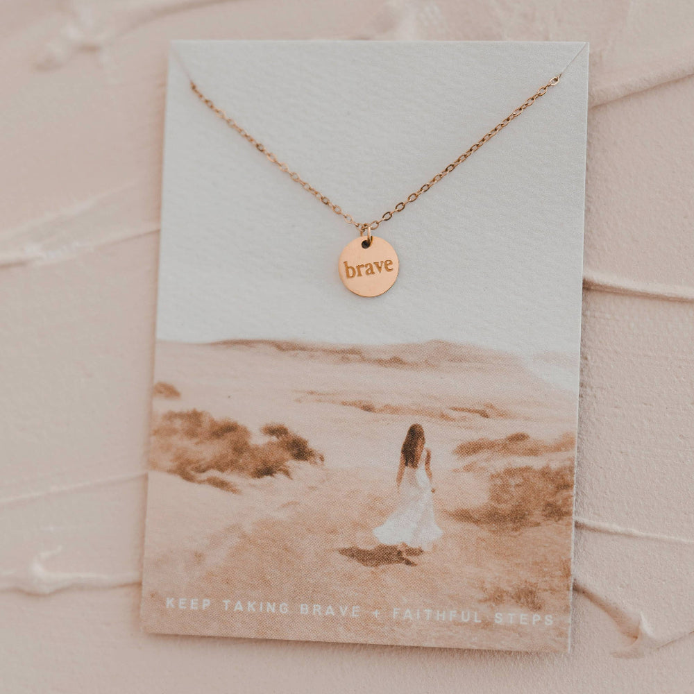 Necklace with 'brave' pendant on a scenic card
