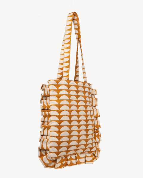 A tote bag with a repeating geometric arch pattern in mustard yellow and off-white, featuring dual shoulder straps, shown against a plain light gray background.