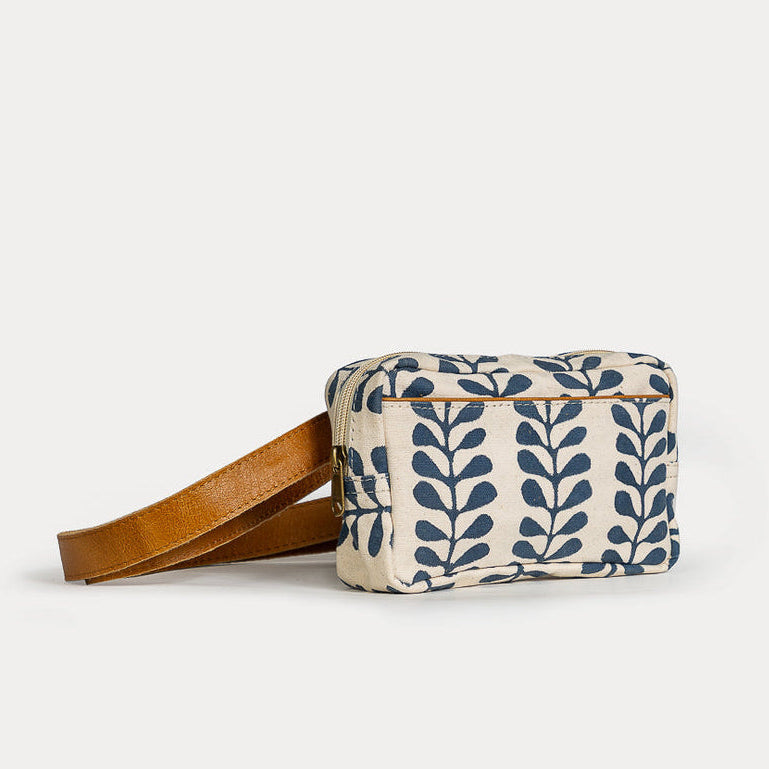 Fabric pouch with leaf pattern and brown strap on a white background