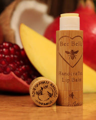 Lip balm with wooden container on a table with fruits in the background