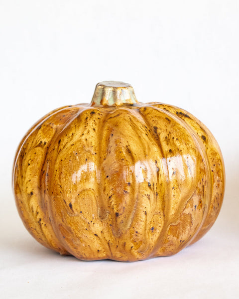 Decorative pumpkin with a marbleized gold and brown pattern on a white background