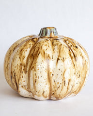 Decorative pumpkin with gold and white marbled pattern on a light gray background
