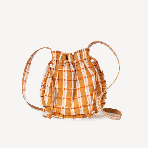 Orange and white checkered bag held by a person with a blurred background