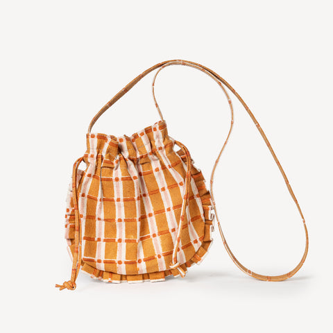 Orange and white checkered bag held by a person with a blurred background