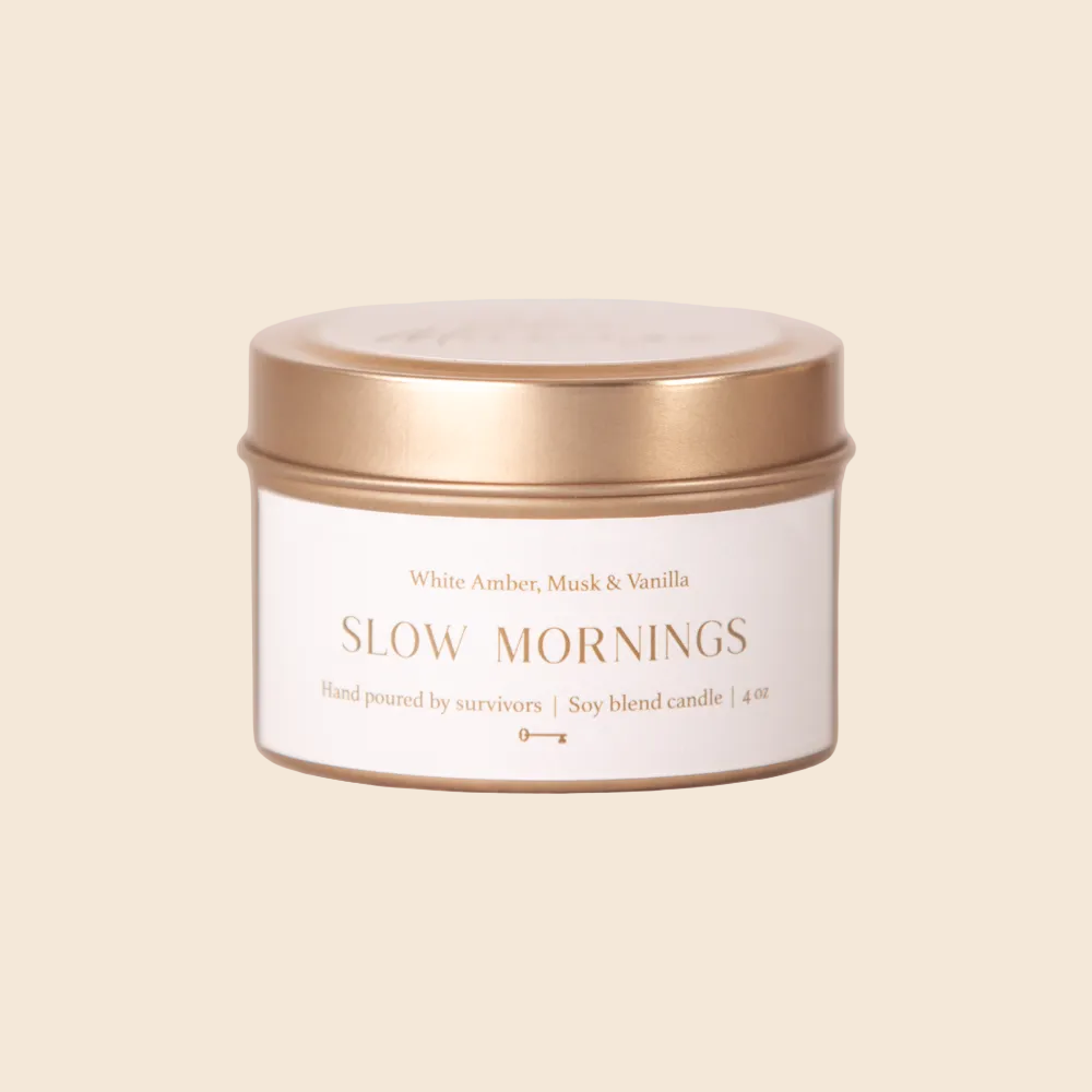 Candle jar labeled 'Slow Mornings' with a gold lid on a white background