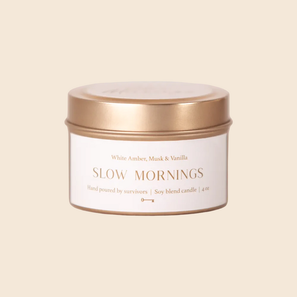 Candle jar labeled 'Slow Mornings' with a gold lid on a white background