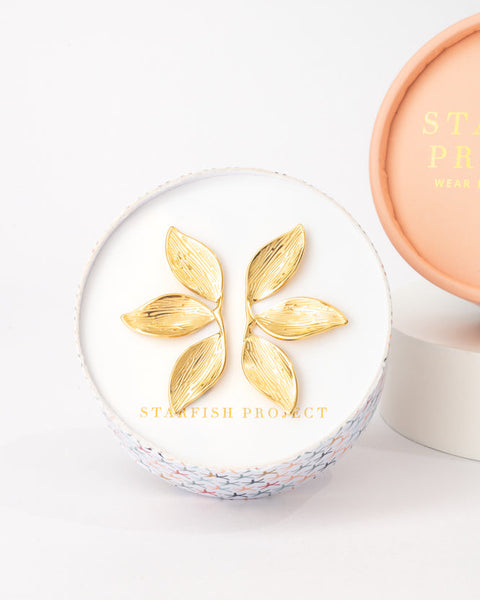 Cosmetic compact with gold leaf design on a white background