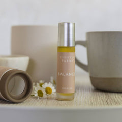 Thistle Farms Balance bottle on a wooden surface with a blurred background