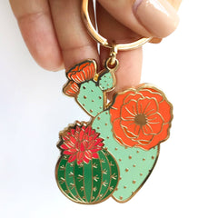 Colorful cactus-shaped keychain held by a hand on a white background